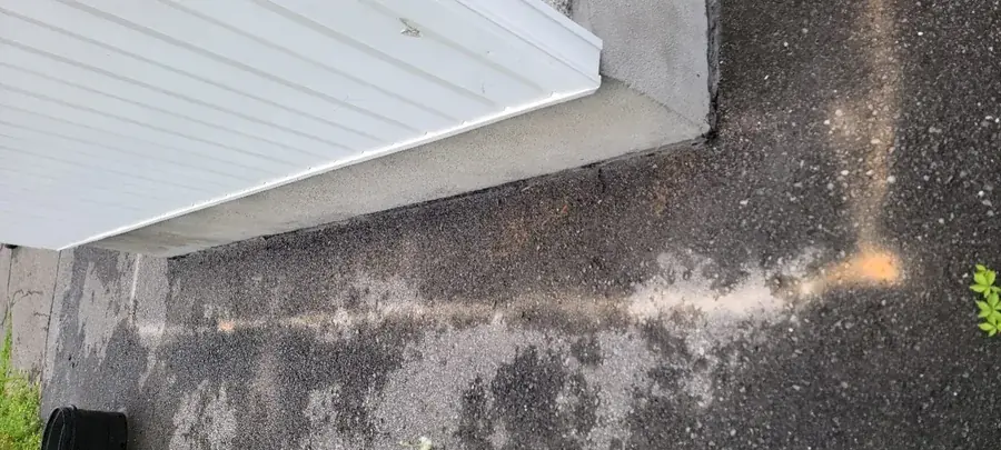 Coupe nette dans l'asphalte au seuil d'un garage
