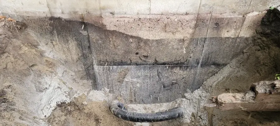 Mur de fondation excavé montrant le trait de coupe et le drain