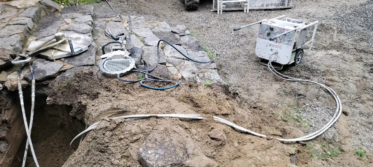 Groupe hydraulique et boyaux d'une scie murale près d'une excavation