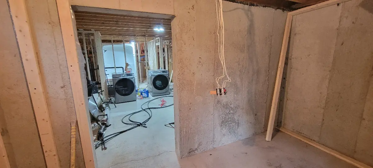 Ouverture de porte sciée dans un mur de blocs de béton, boyaux au sol