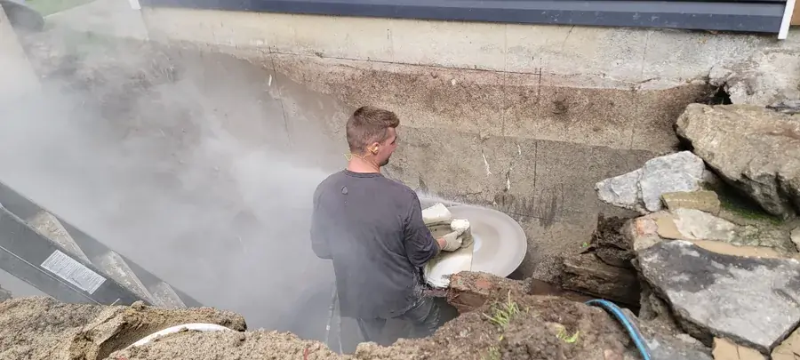 Sciage d'un mur de fondation à la scie hydraulique dans une excavation